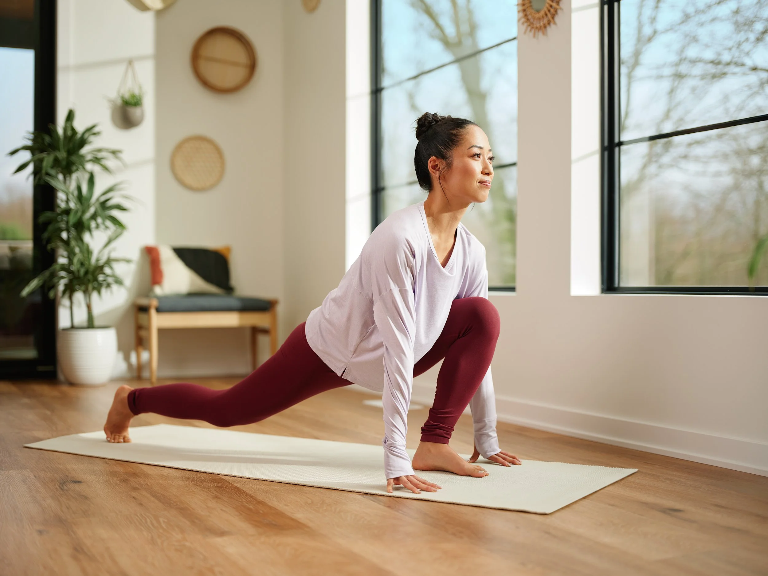 Girl practicing yoga indoors, representing a health and wellbeing lifestyle.