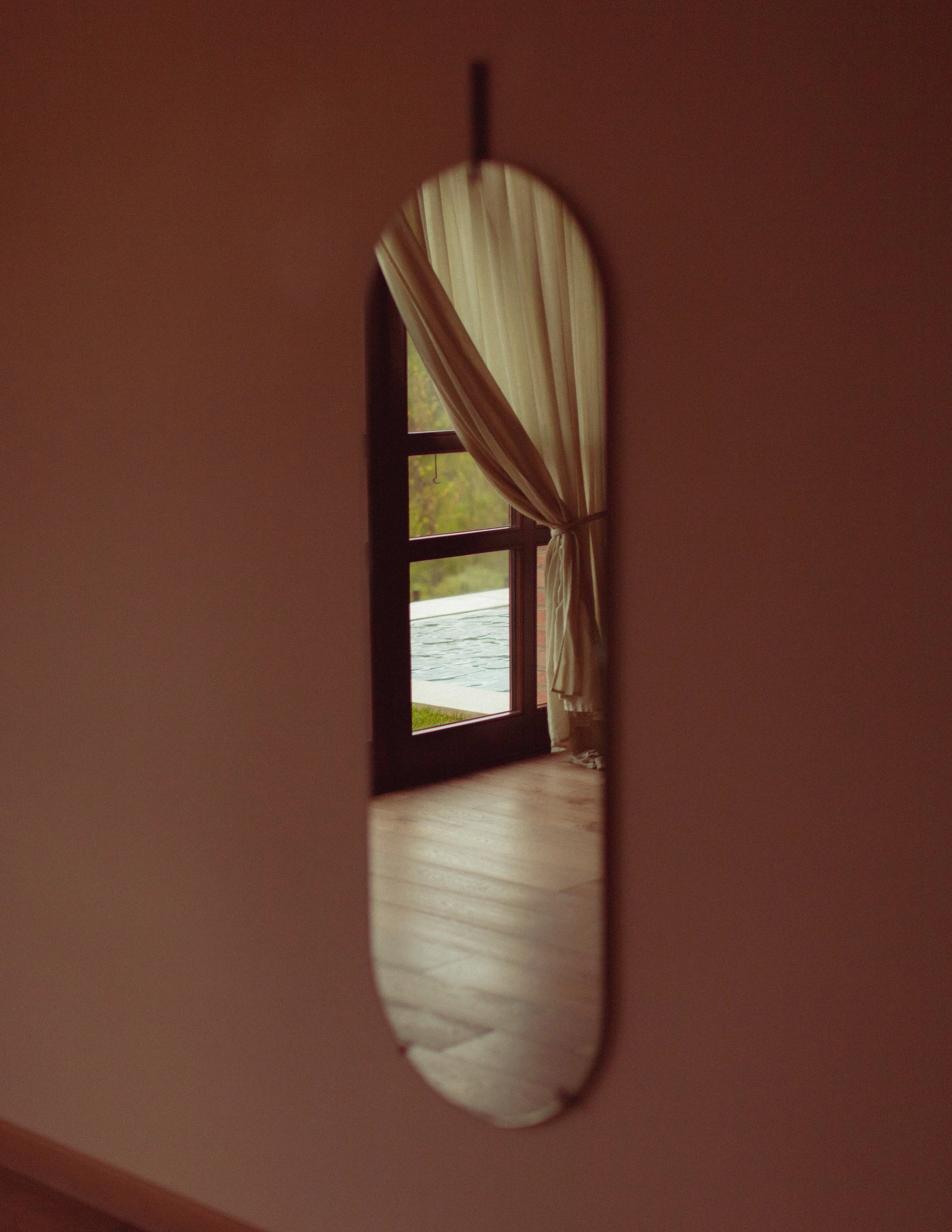 relfection of hotel pool through oval mirror