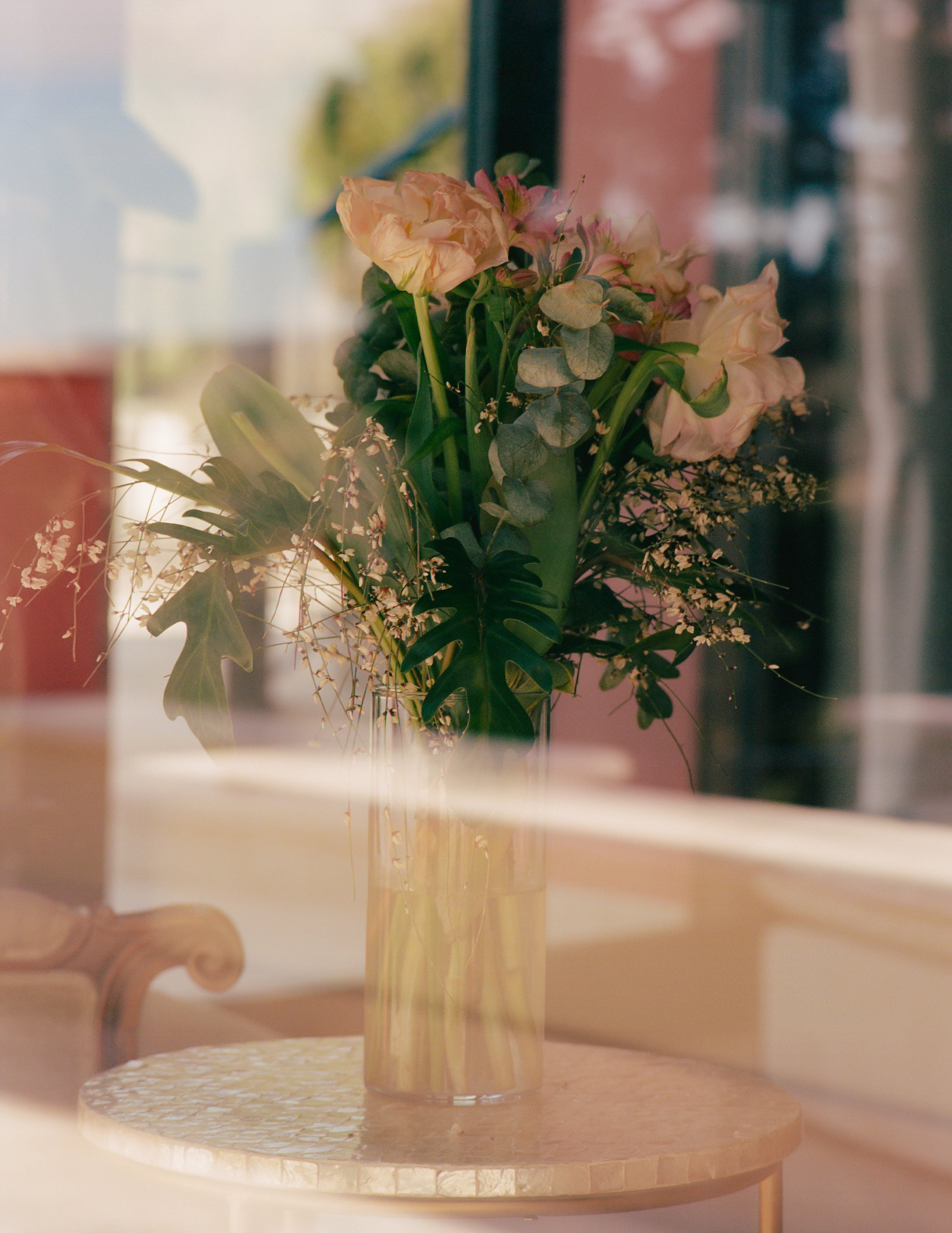 flowers in a vase through a window