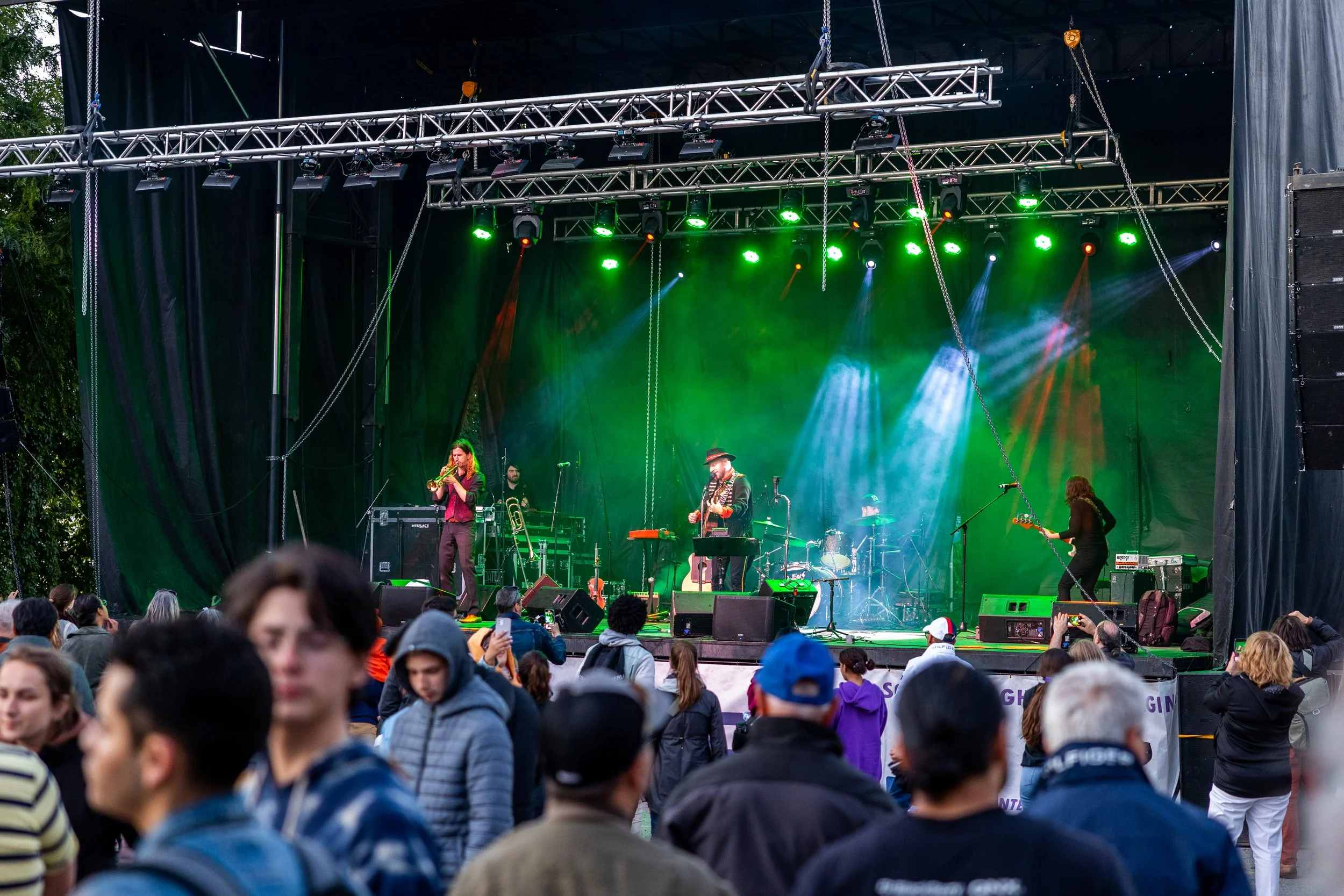 Live band performing on outdoor stage with audience