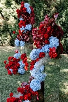 Blue hydrangea and red rose ceremony arbour for a sky blue and maroon wedding