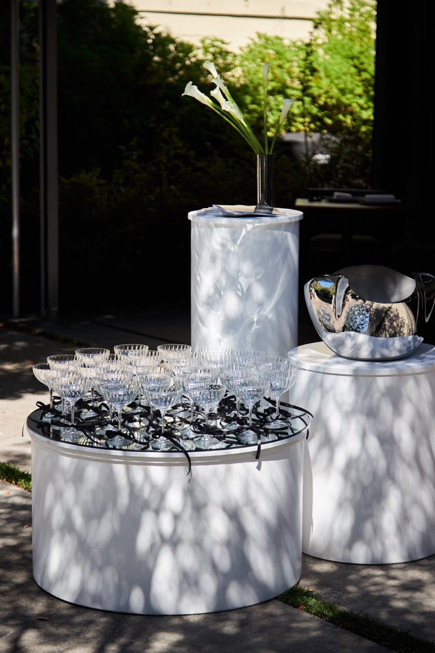 Outdoor table setup with glassware, flowers, and a silver bowl