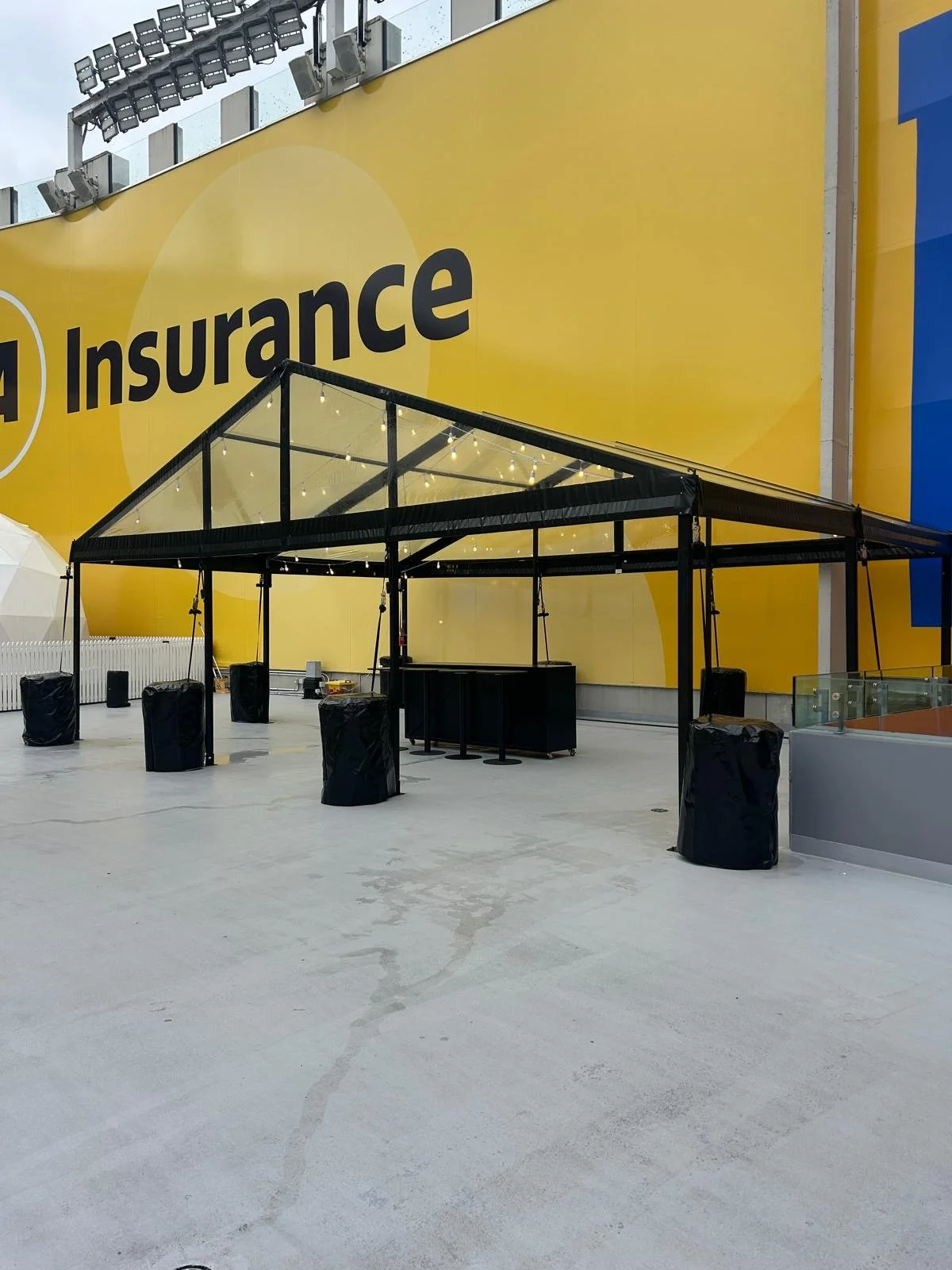 9m wide black frame clear marquee with bar leaners set up for a corporate event