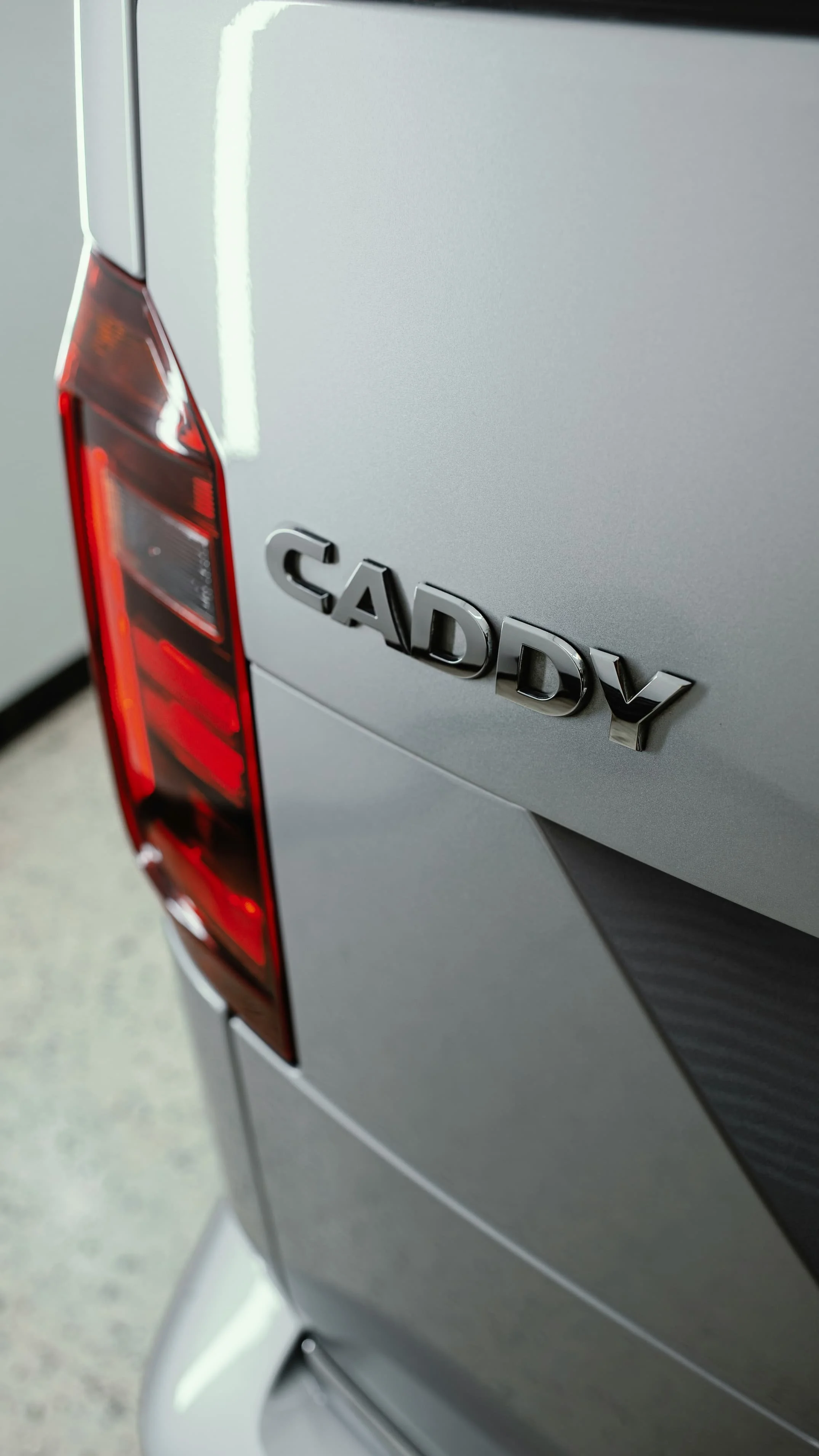 Close-up of Volkswagen Caddy rear badge showing the compact van platform often used for micro camper conversions | which VW campervan size is right for you | Cornwall
