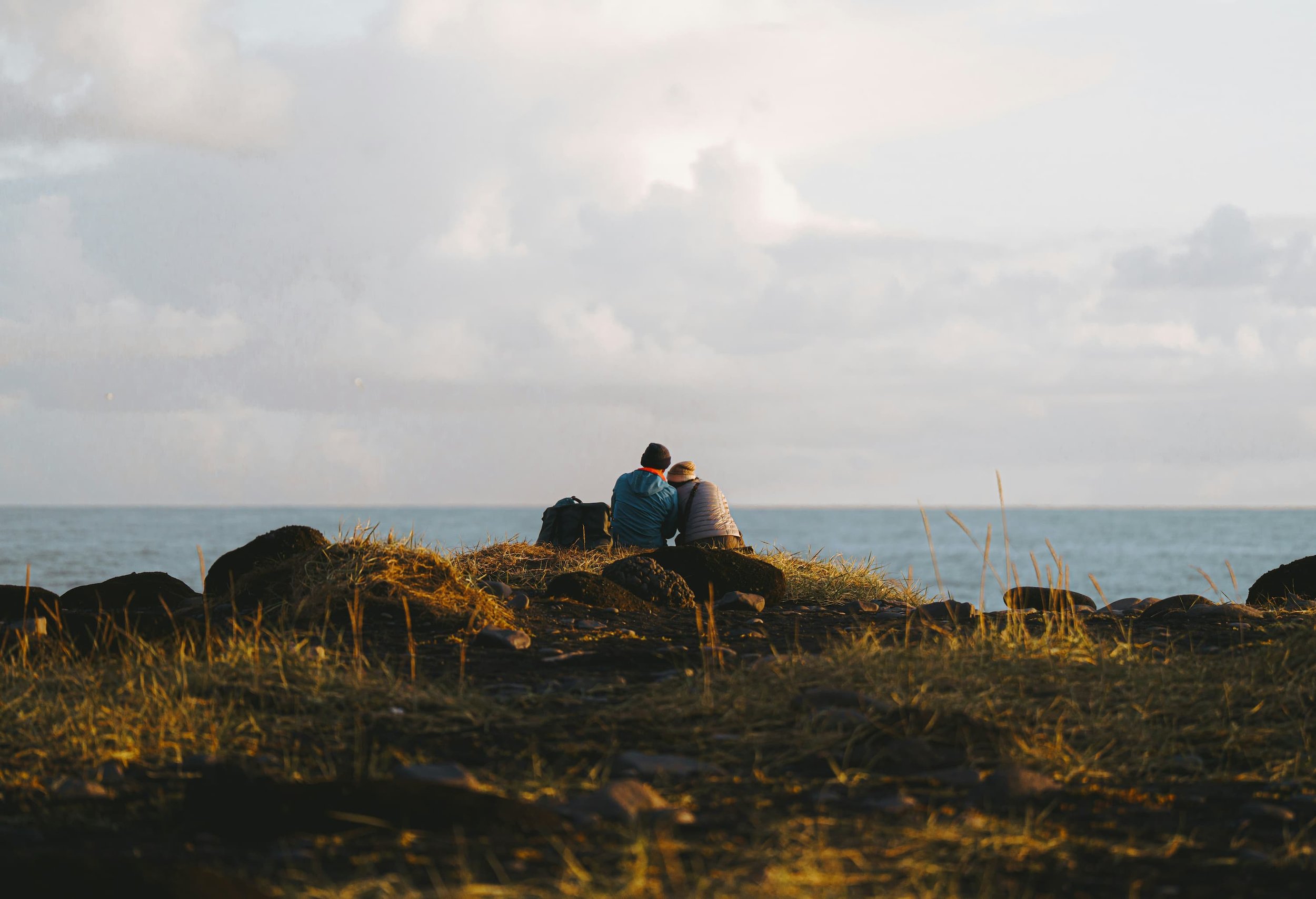 Couple sat on the cliff in the evening | VW Transporter conversion | Cornwall