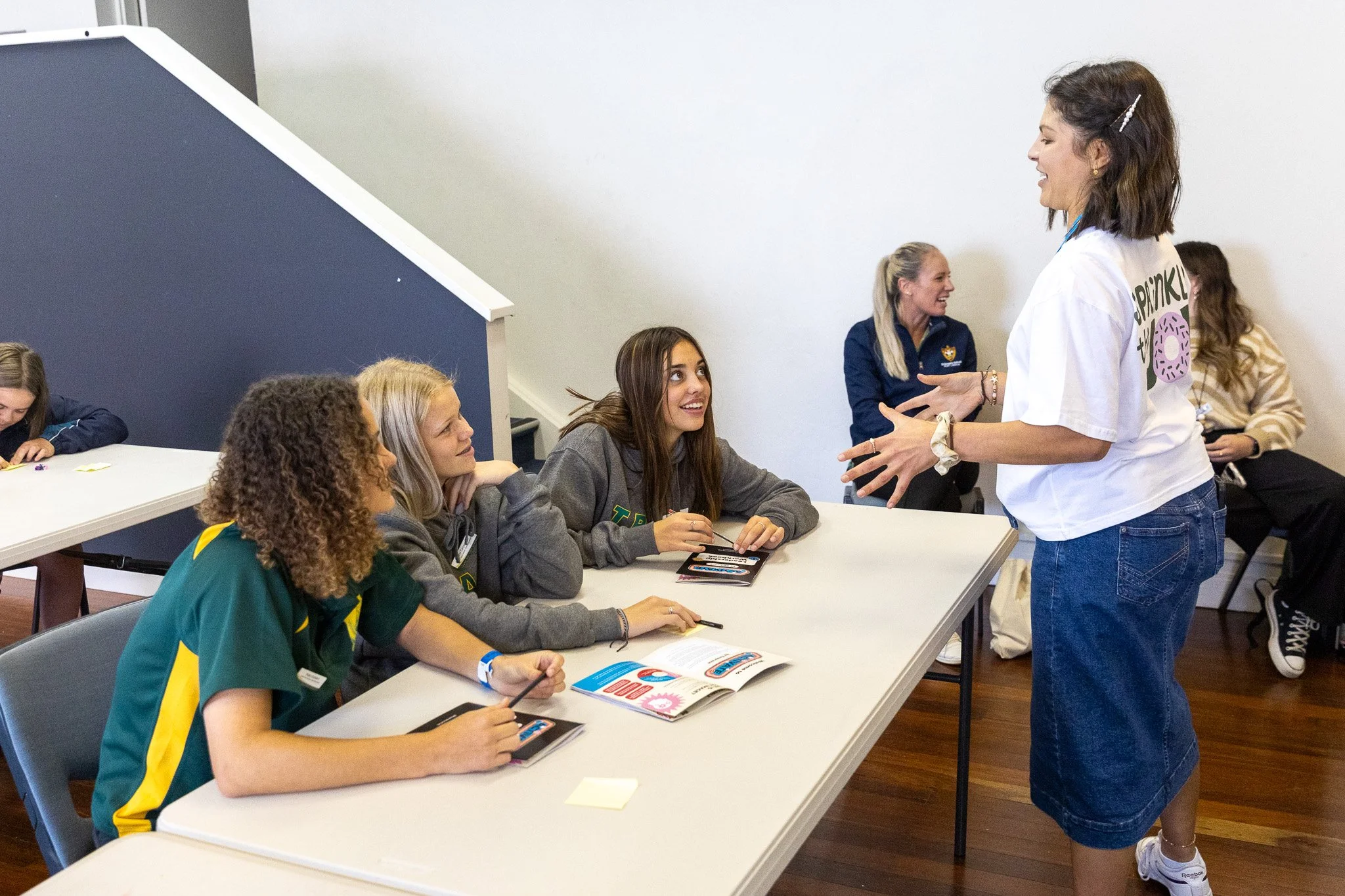 Gel chatting with three Year 9 students at their desk