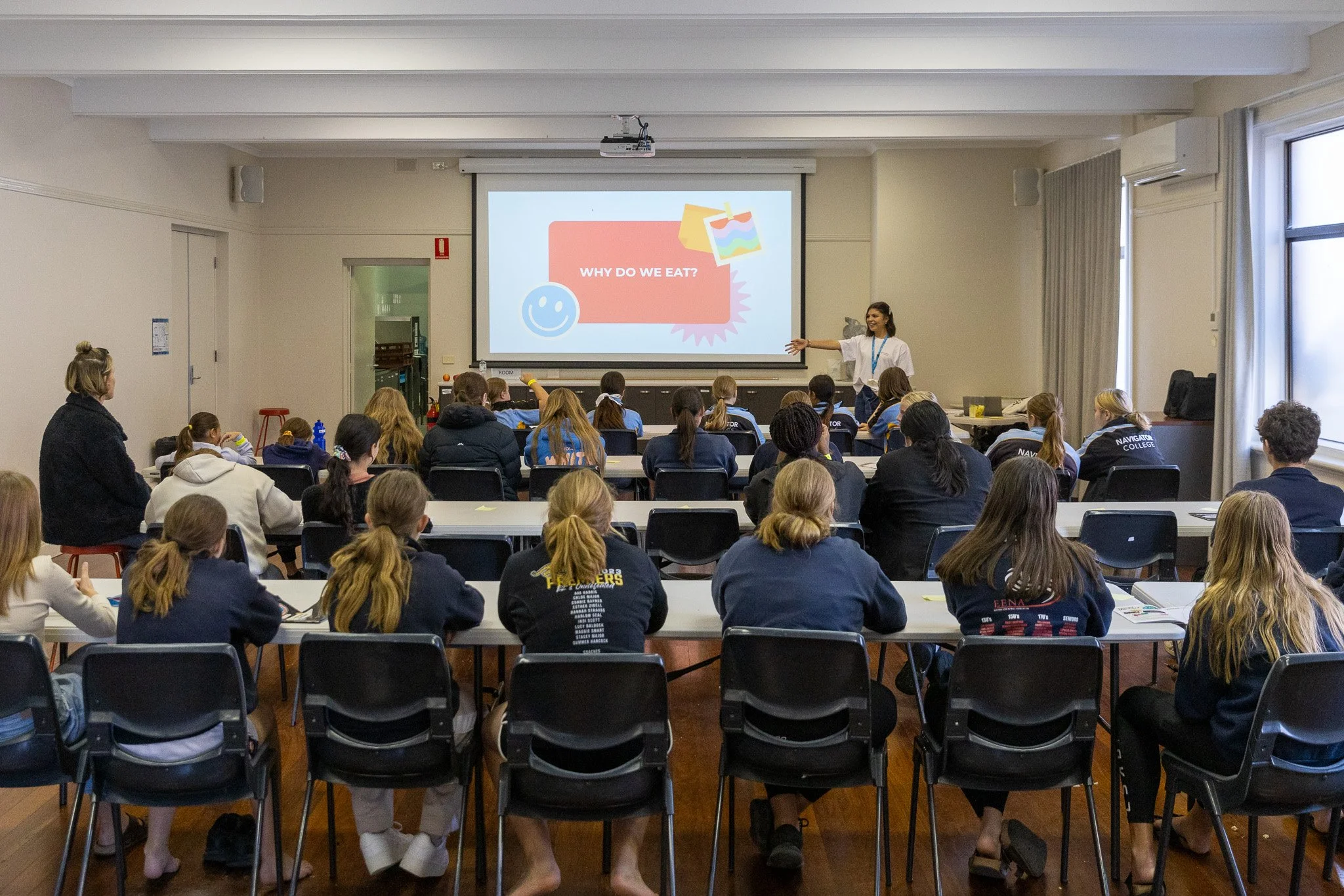 Gel presenting to a full classroom of students