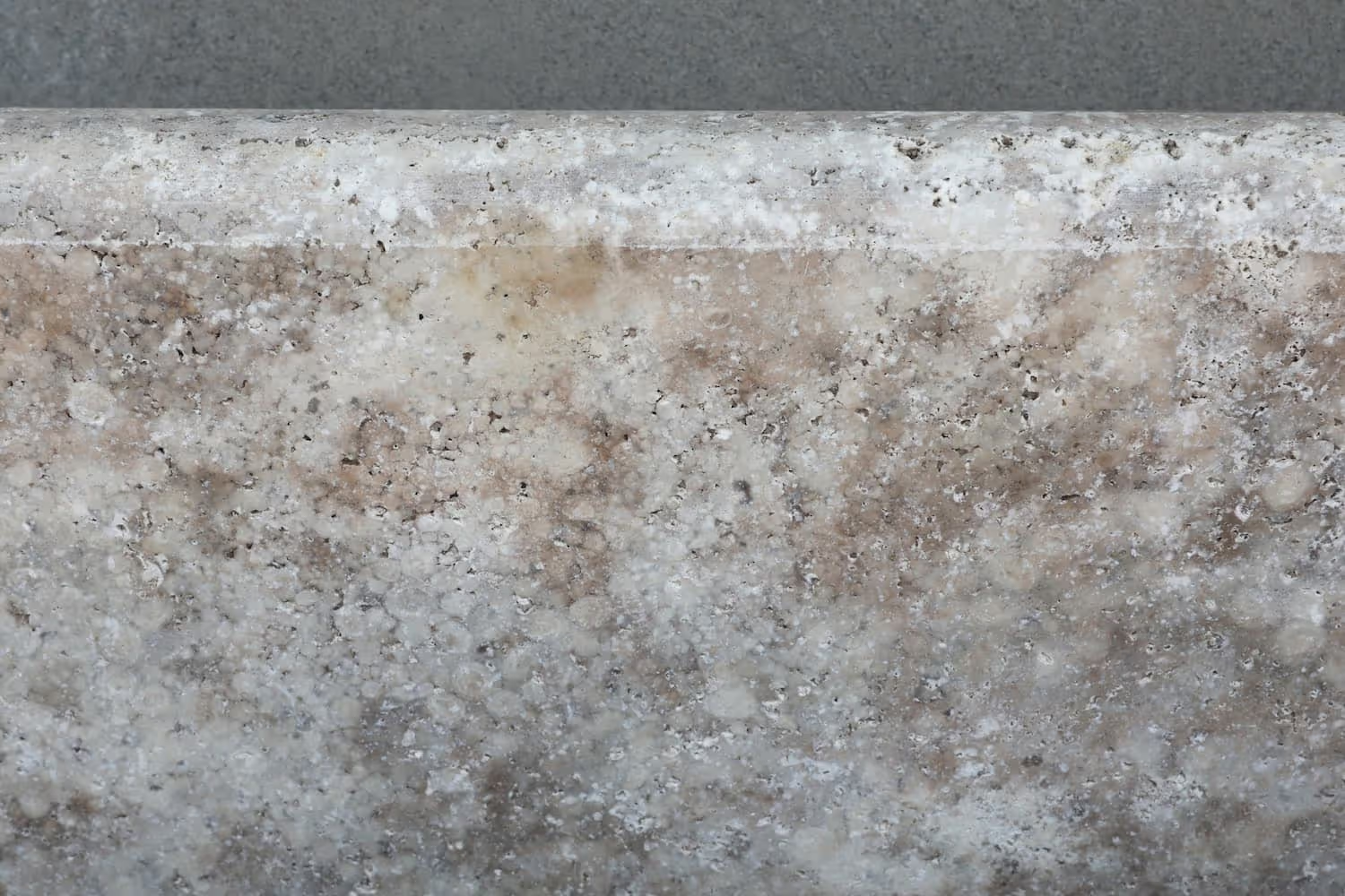 Close-up of a granite countertop with mixed beige, white, and brown speckles.