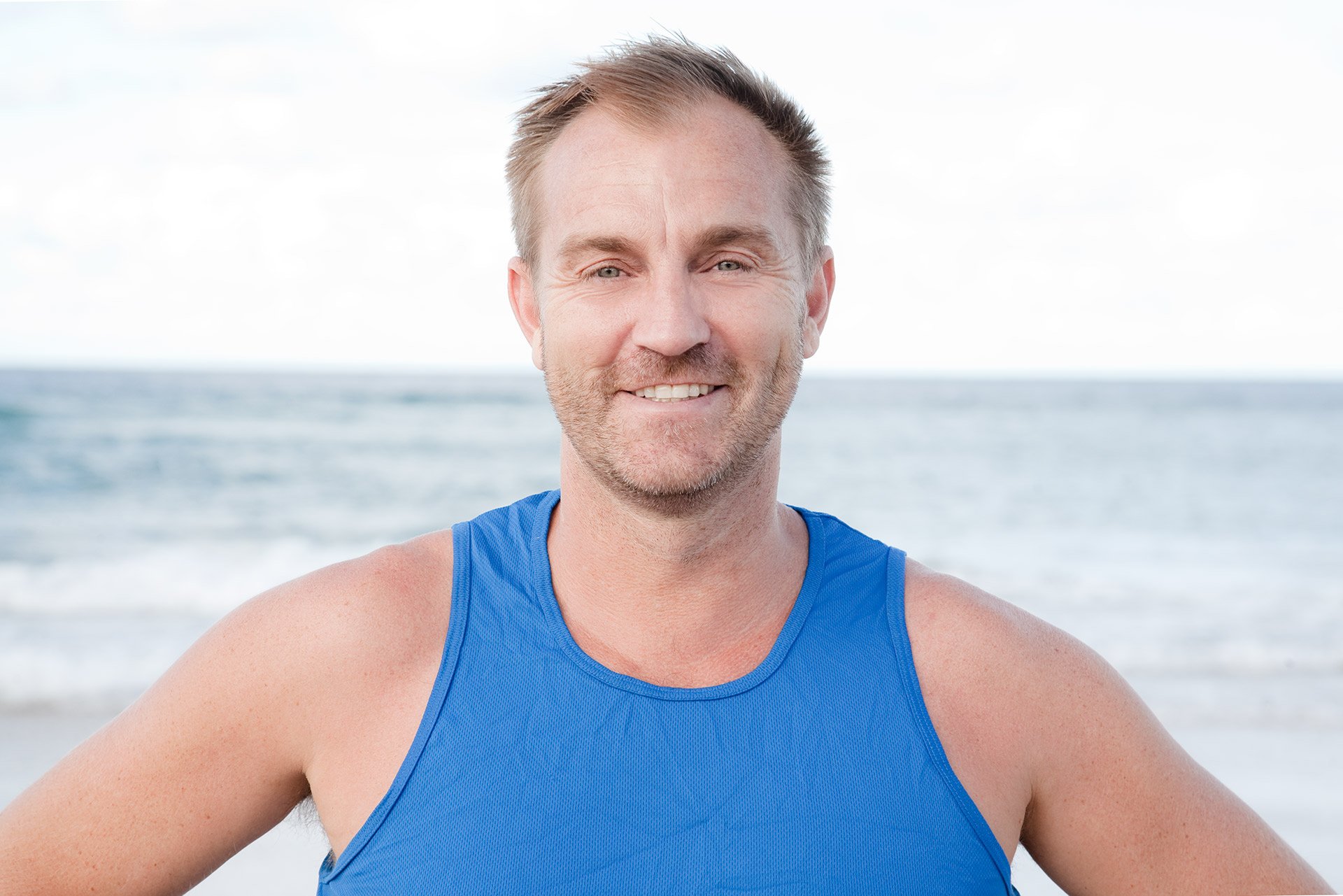  man at beach smiling at camera gold coast kirsten cox photographer portraits 