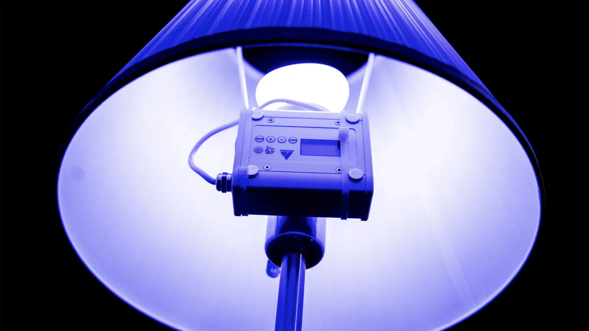 Astera NYX Bulb glowing blue inside a reflective lamp shade
