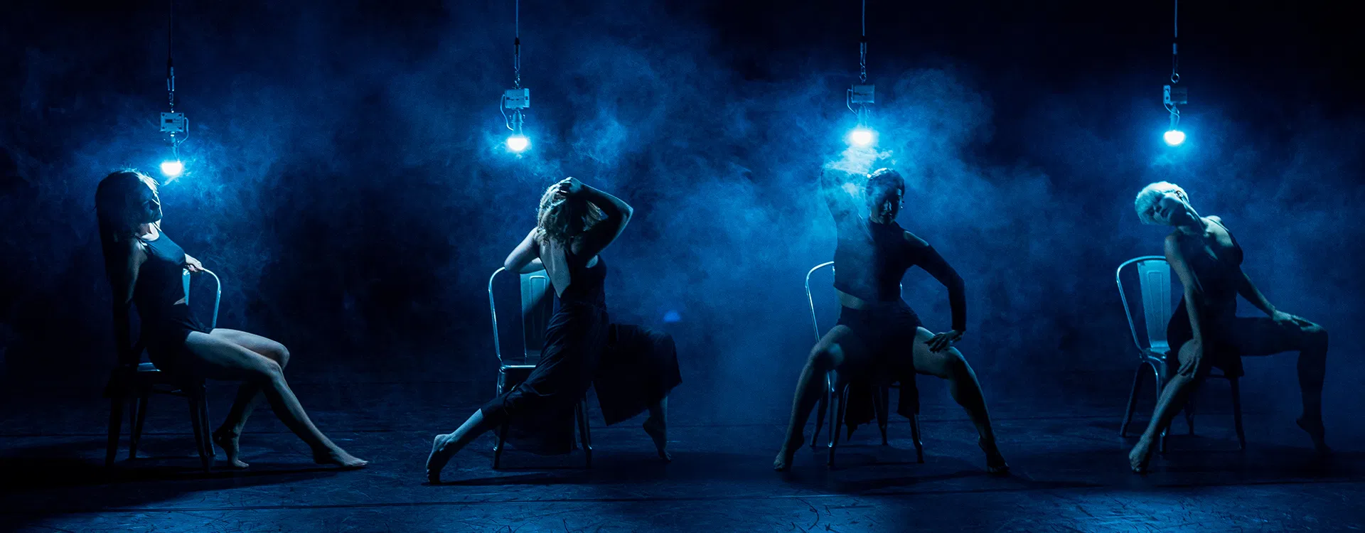 Dancers on a hazy stage lit in blue with Astera NYX Bulbs