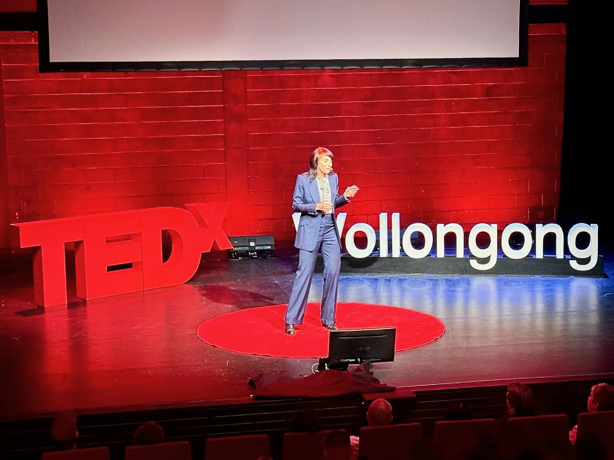 Dr Meghan Dares speaking on stage at TEDxWollongong about healthspan, mobility and ageing well.
