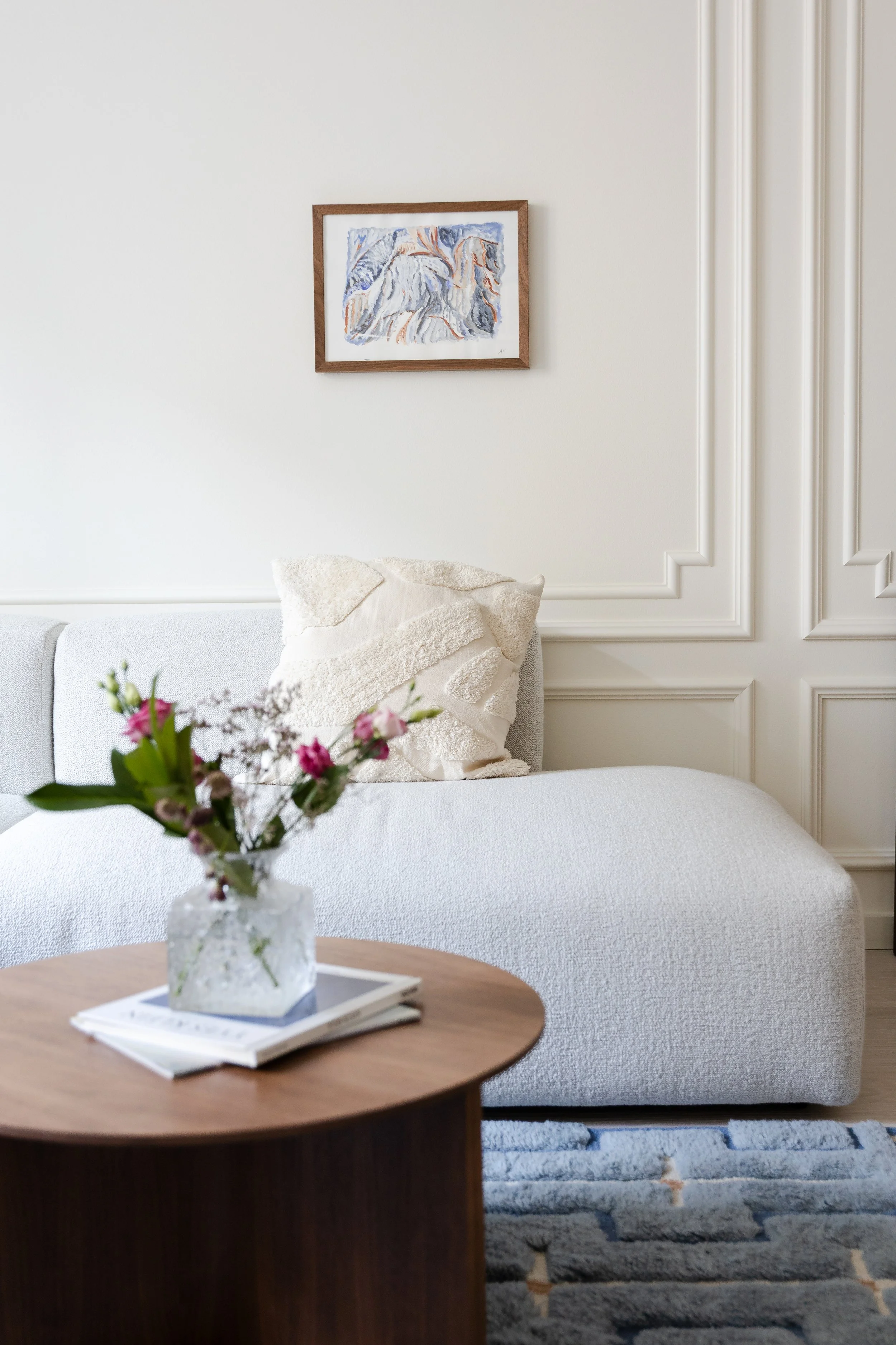 Wall moldings, module sofa, wool rug, coffee table, frames