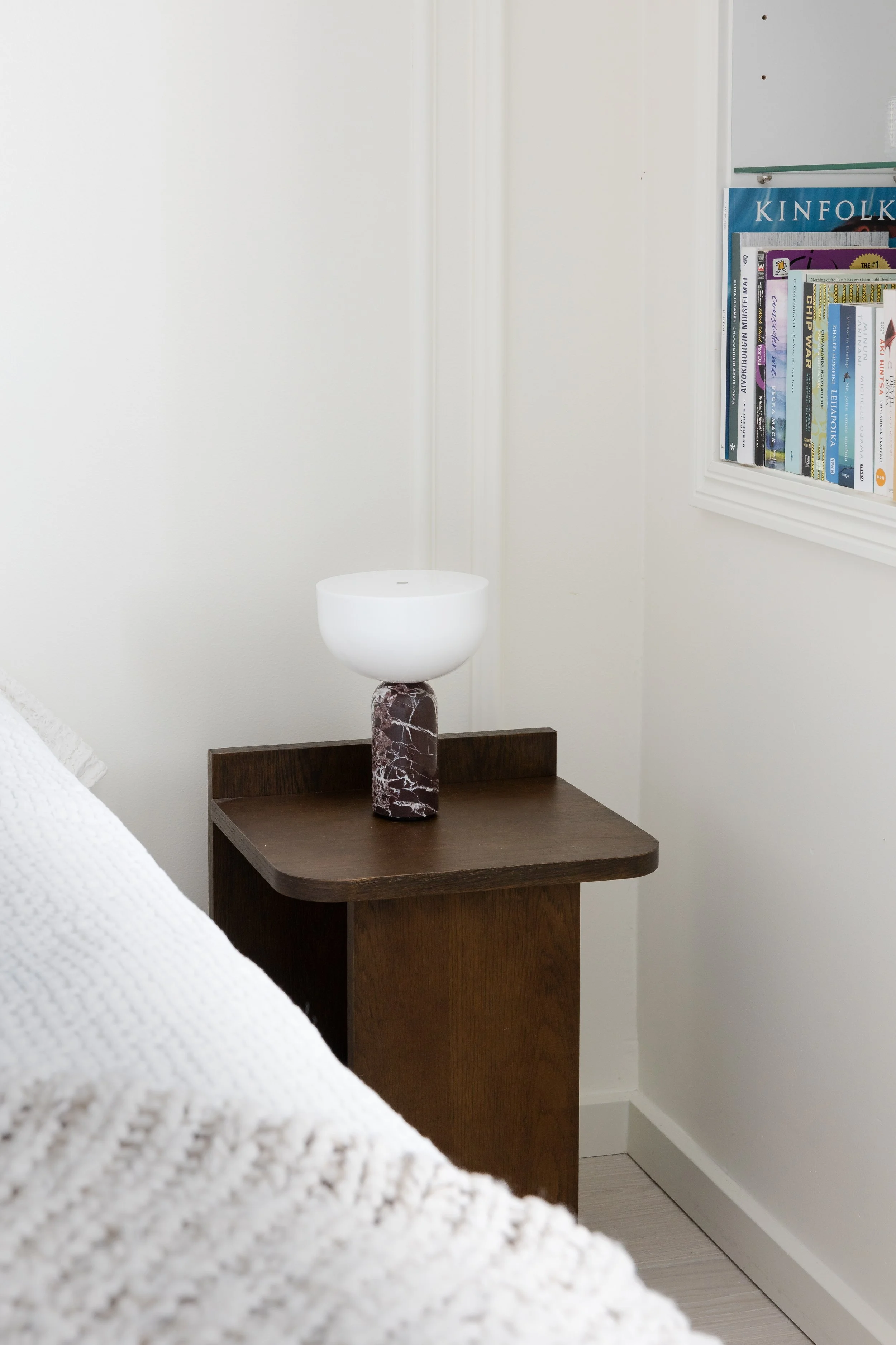 Nightstand made of solid wood, portable table lamp with real marble. Wall moldings continue into the bedroom