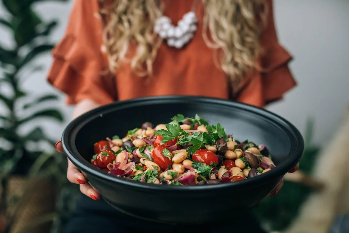 Mary holding a bowl filled with vegetables.