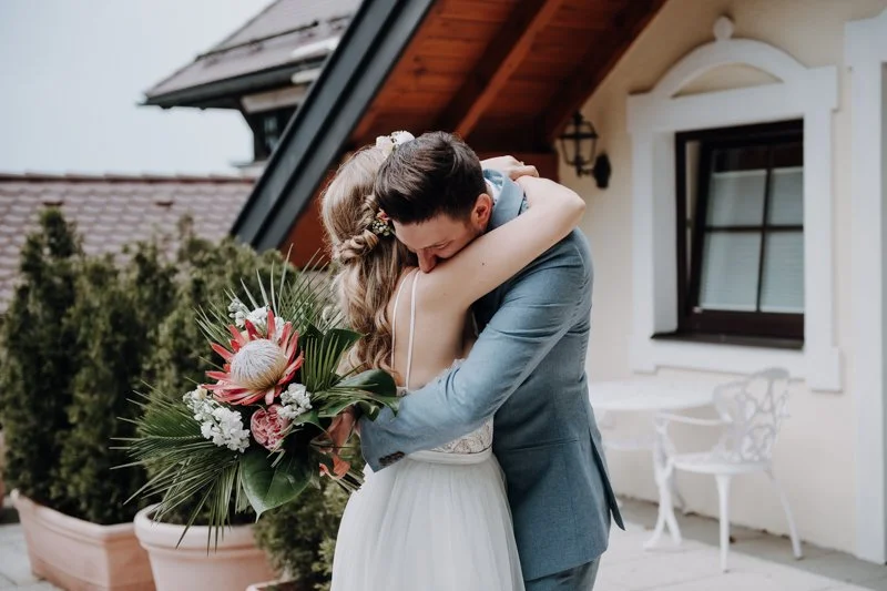 Hawaii Motto Hochzeit beim Fuschlsee im Salzkammergut in der Hochzeitslocation Ansitz Wartenfels am Berg. Claudia Weaver fotografiert den Ersten Blick/ First Look des Brautpaares wenn sie sich das erste Mal in Brautkleid und Hochzeitsanzug sehen.