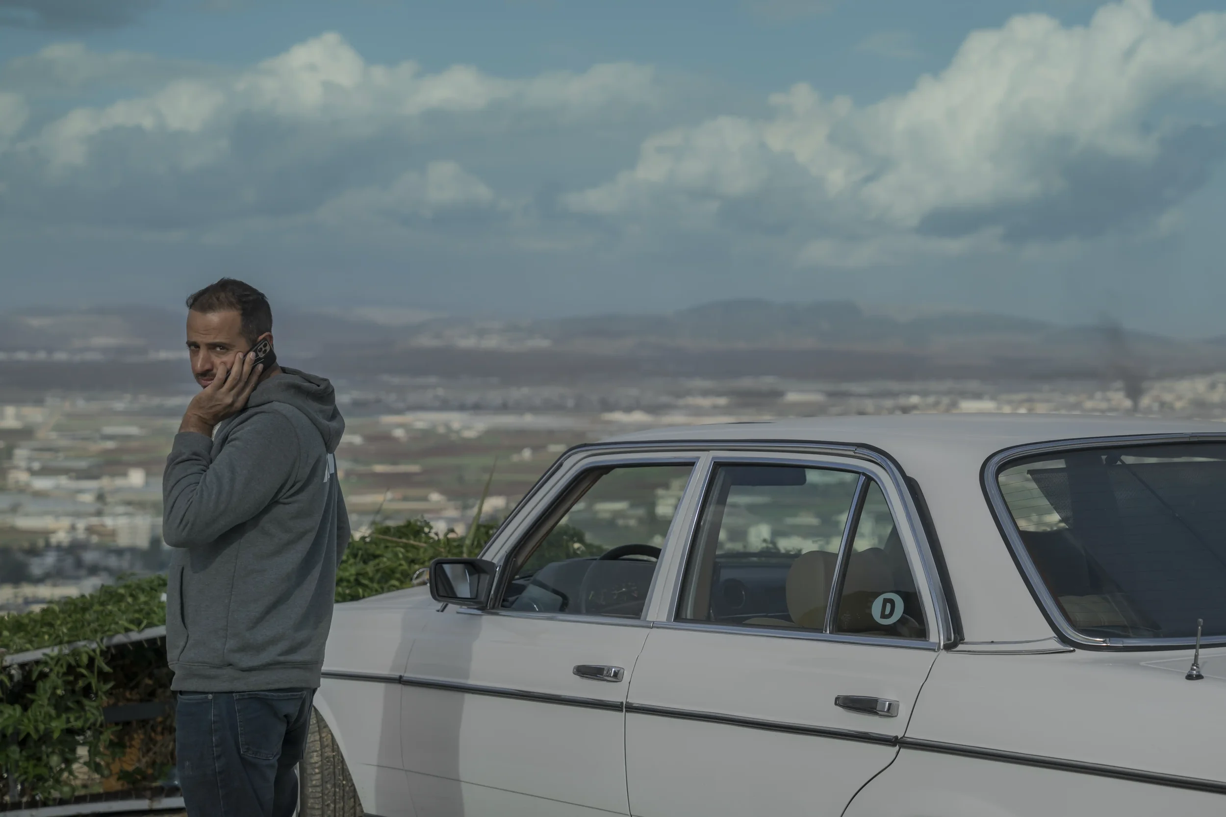 Overlooking Jenin refugee camp, Osaid— a former taxi driver now working as a courier — speaks on the phone beside his car, planning routes in a city where raids and military operations have become daily events.
Jenin - November 2025
