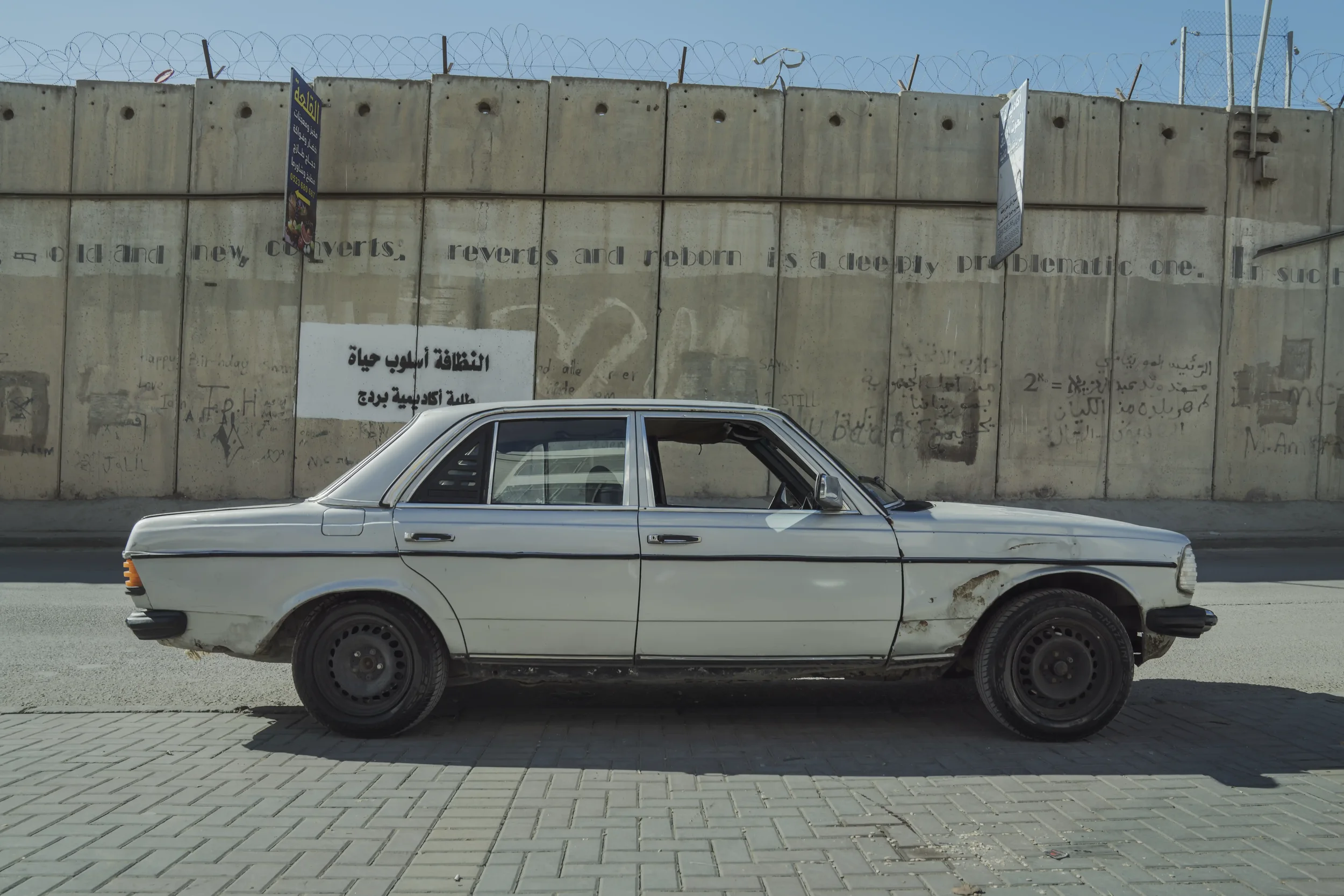Khamis’s Mercedes stands by the separation wall near the Qalandiya checkpoint, where travel time is measured in queues and unpredictable stops.
Qalandia Village - November 2025
