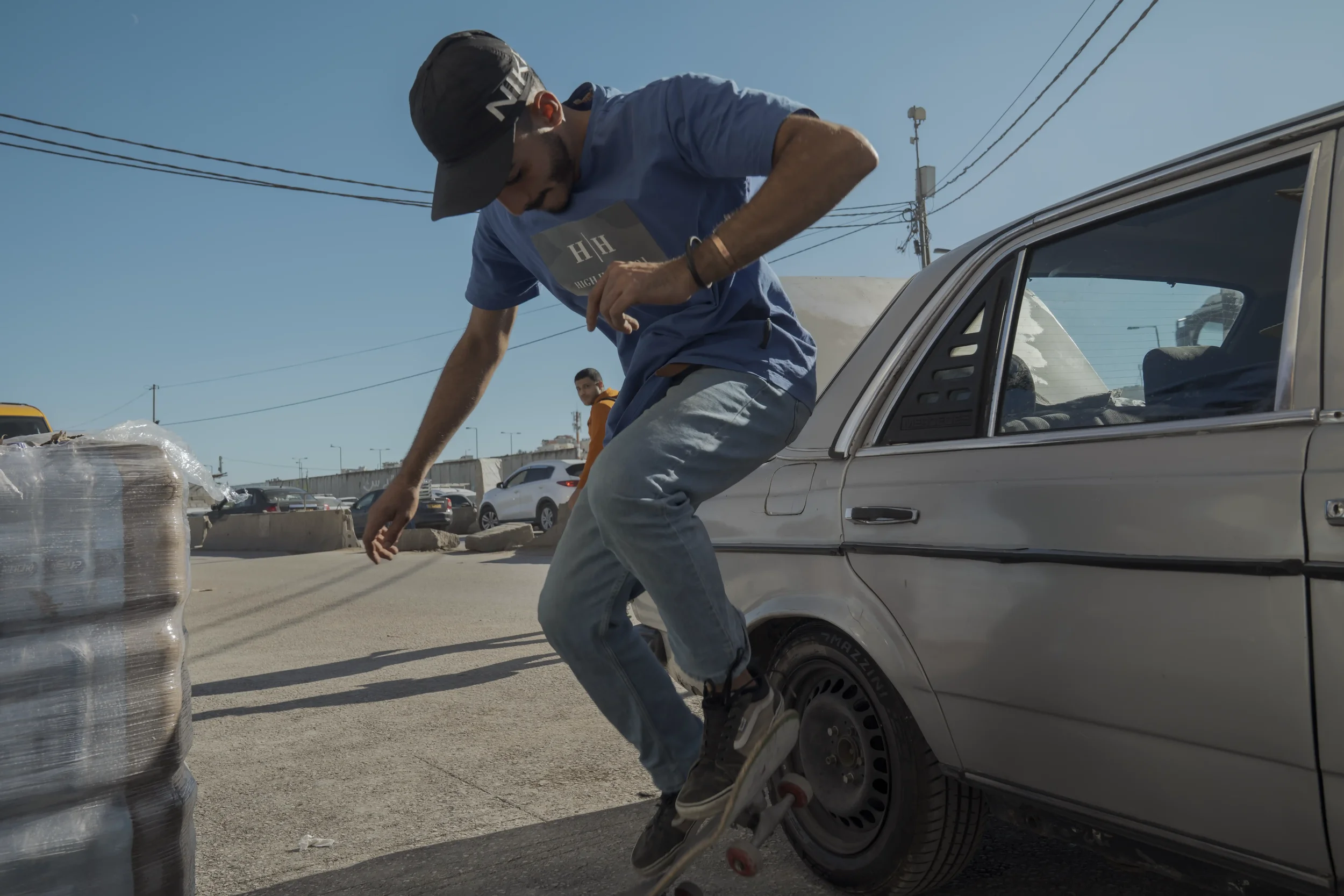 Khamis practices skateboard tricks while waiting for traffic to move. It is his way of filling the time taken by checkpoints and closures.
Qalandia Village - November 2025