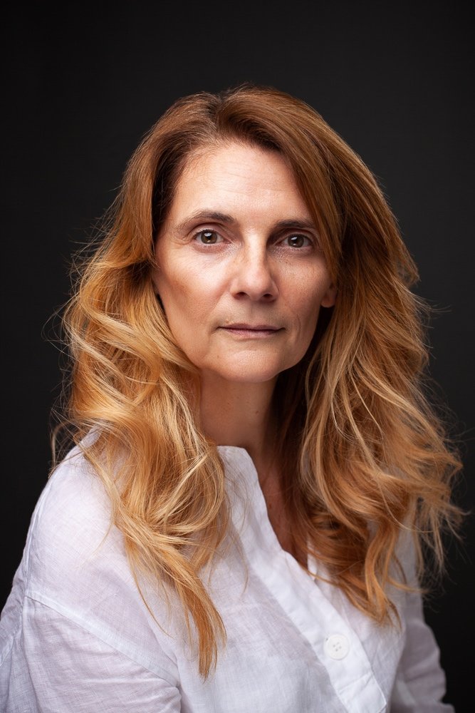 Laurence Trolet, London photographer, in a professional headshot against a dark background