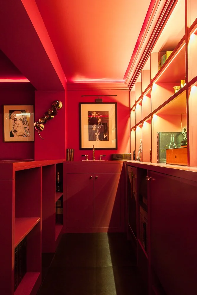 Private home bar shelving with lit display and bottles, interior photographer Chelsea