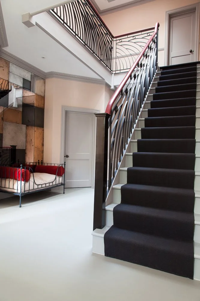 Staircase with wrought-iron banister and dark carpet runner, interior design photographer London, Clapham
