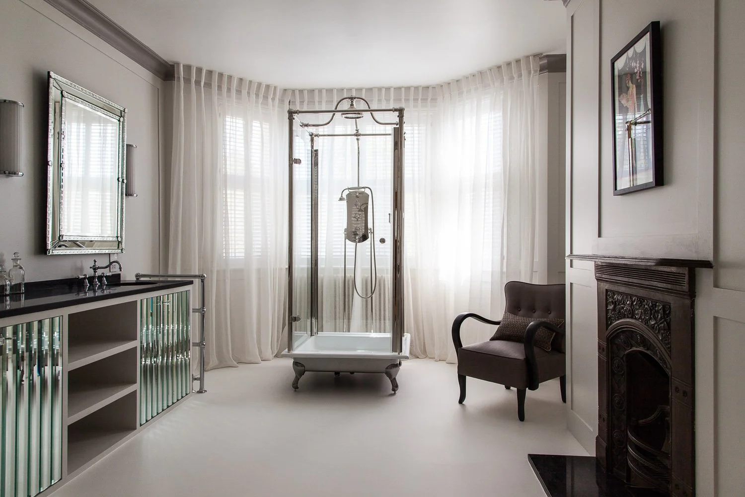 Master ensuite with mirrored cabinetry, freestanding bath and dark fireplace, interior photography, Clapham