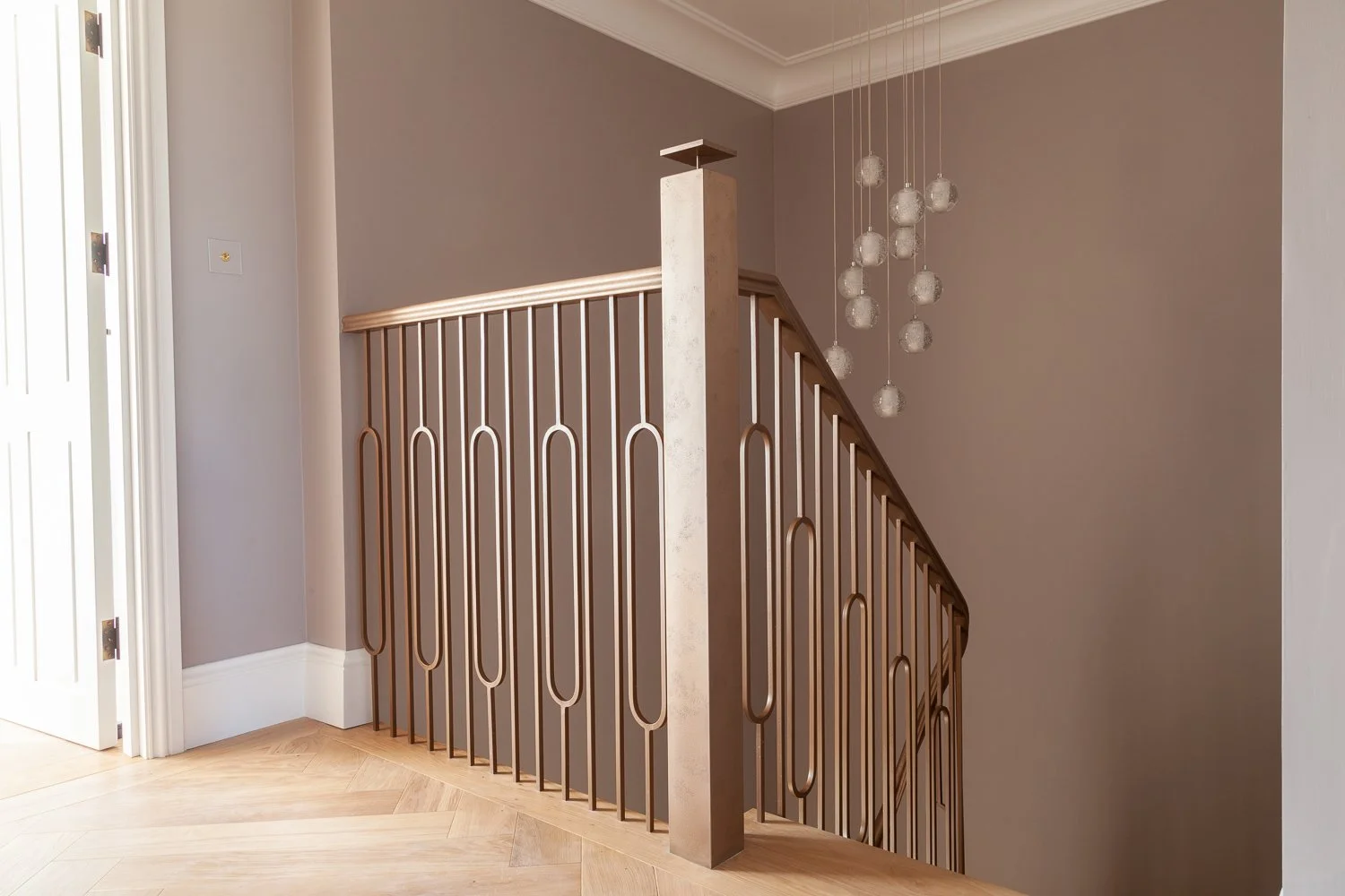 Staircase with geometric metal balustrade and pendant lighting detail, interior design photographer, Mayfair