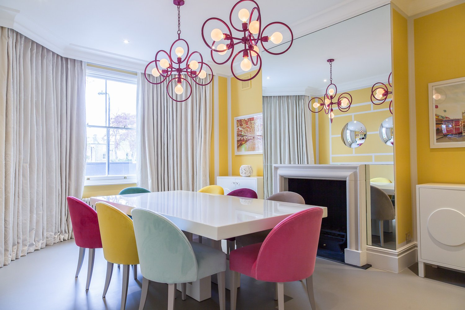 Dining room with sculptural pendant lighting and mixed jewel-toned chairs, interior design photography, Clapham