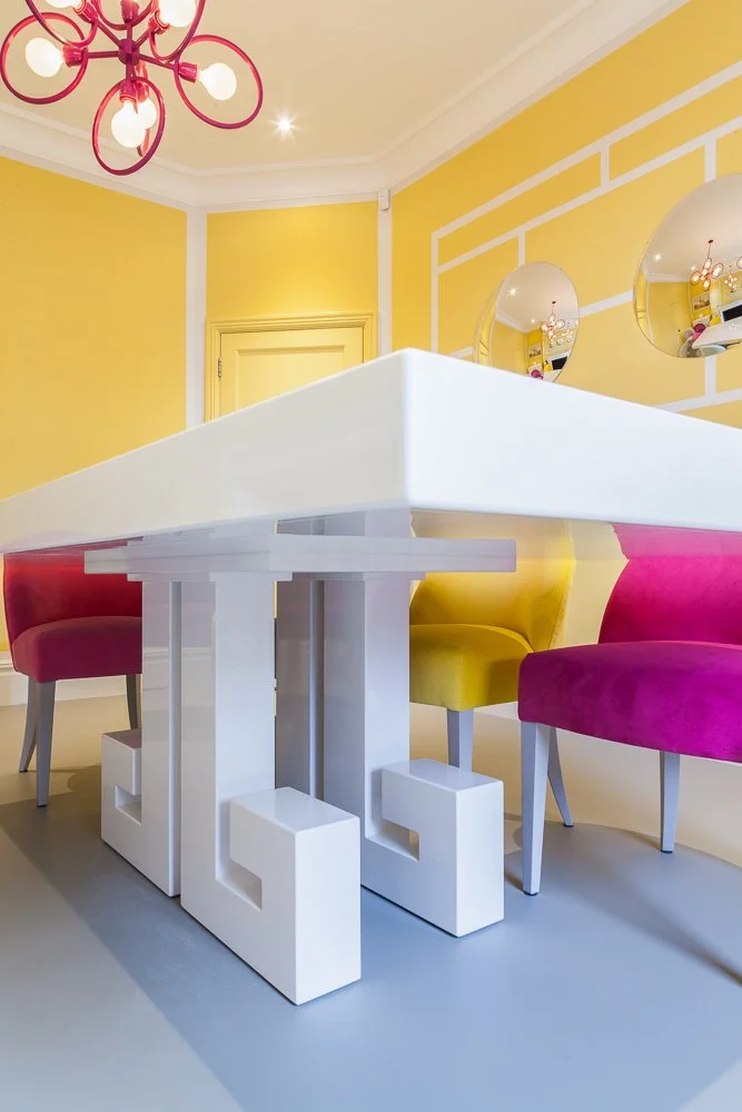 Close-up of a sculptural dining table's crafted base, with pink velvet chairs, interior photographer, Clapham