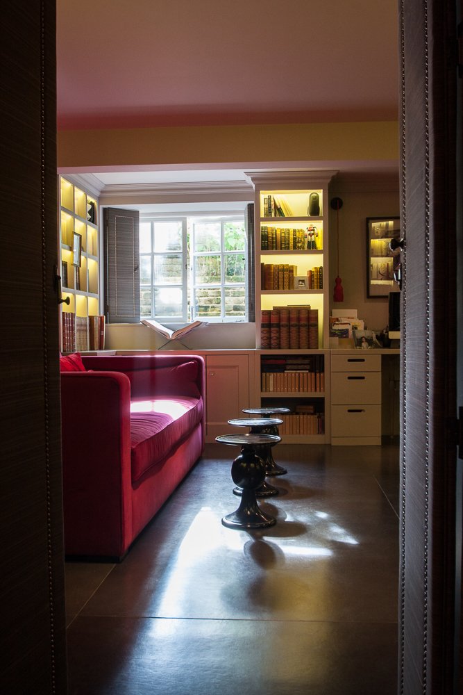 Home library with red velvet sofa and built-in bookshelves, interior photography, Chelsea