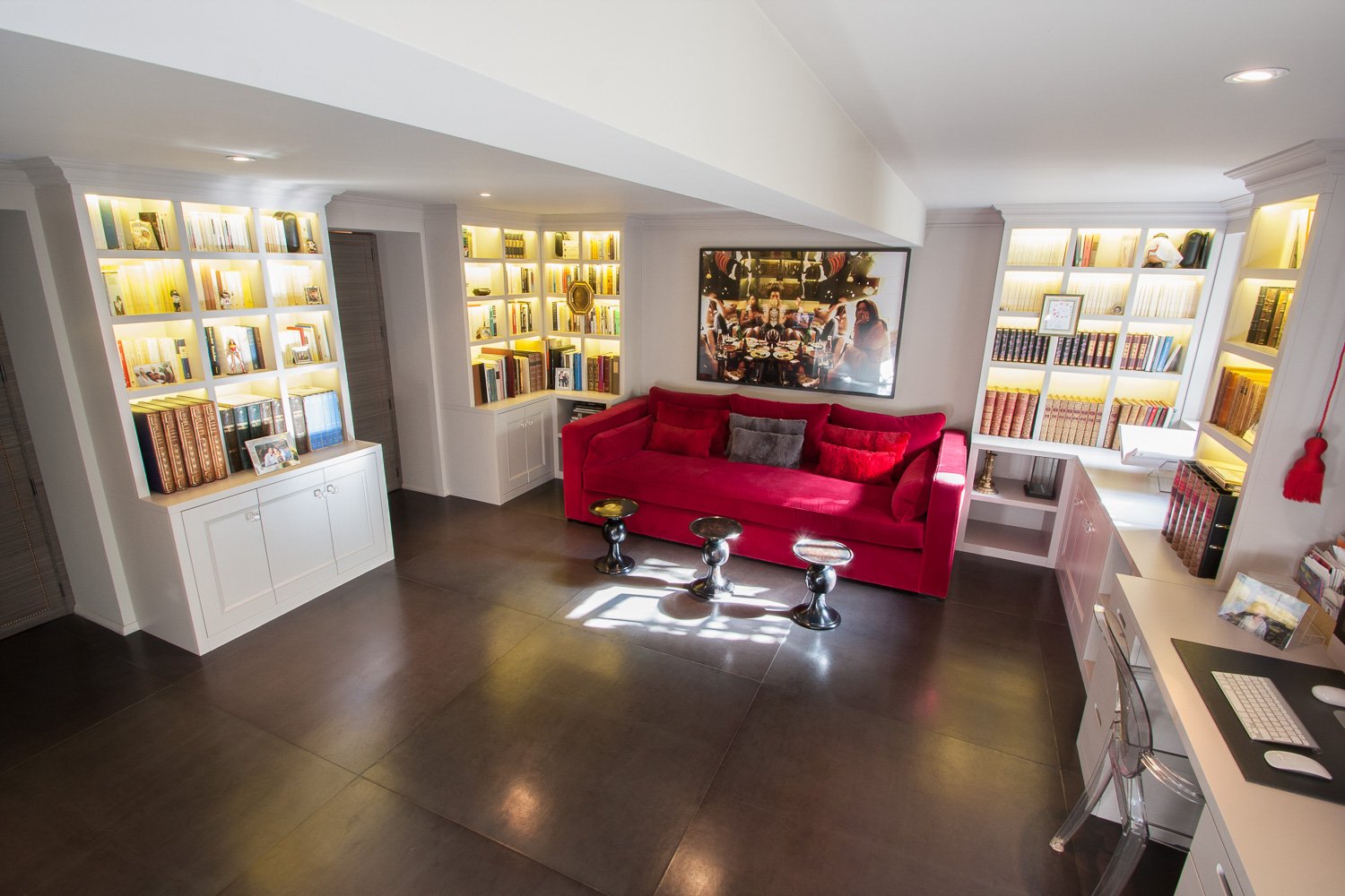 Wide view of a home library with dark flooring, red sofa and gallery wall, interior design photography, Chelsea