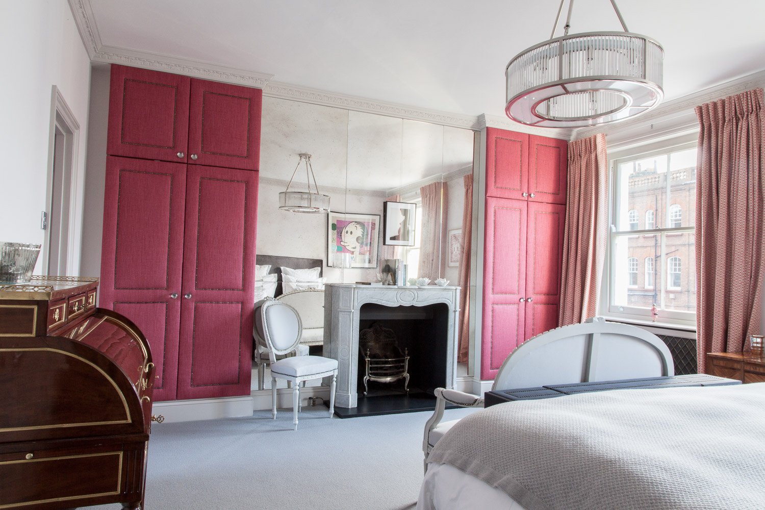 Bedroom with pink panelled wardrobes and a decorative fireplace, interior design photographer, Chelsea