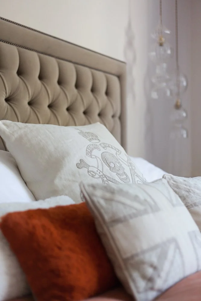 Close-up of a tufted headboard with layered patterned cushions, interior photographer, Chelsea