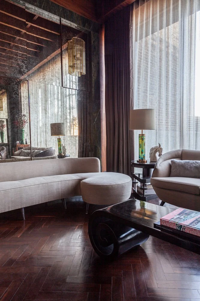 Living room with dark wood flooring, curved sofa and round coffee table, interior photographer, Clapham