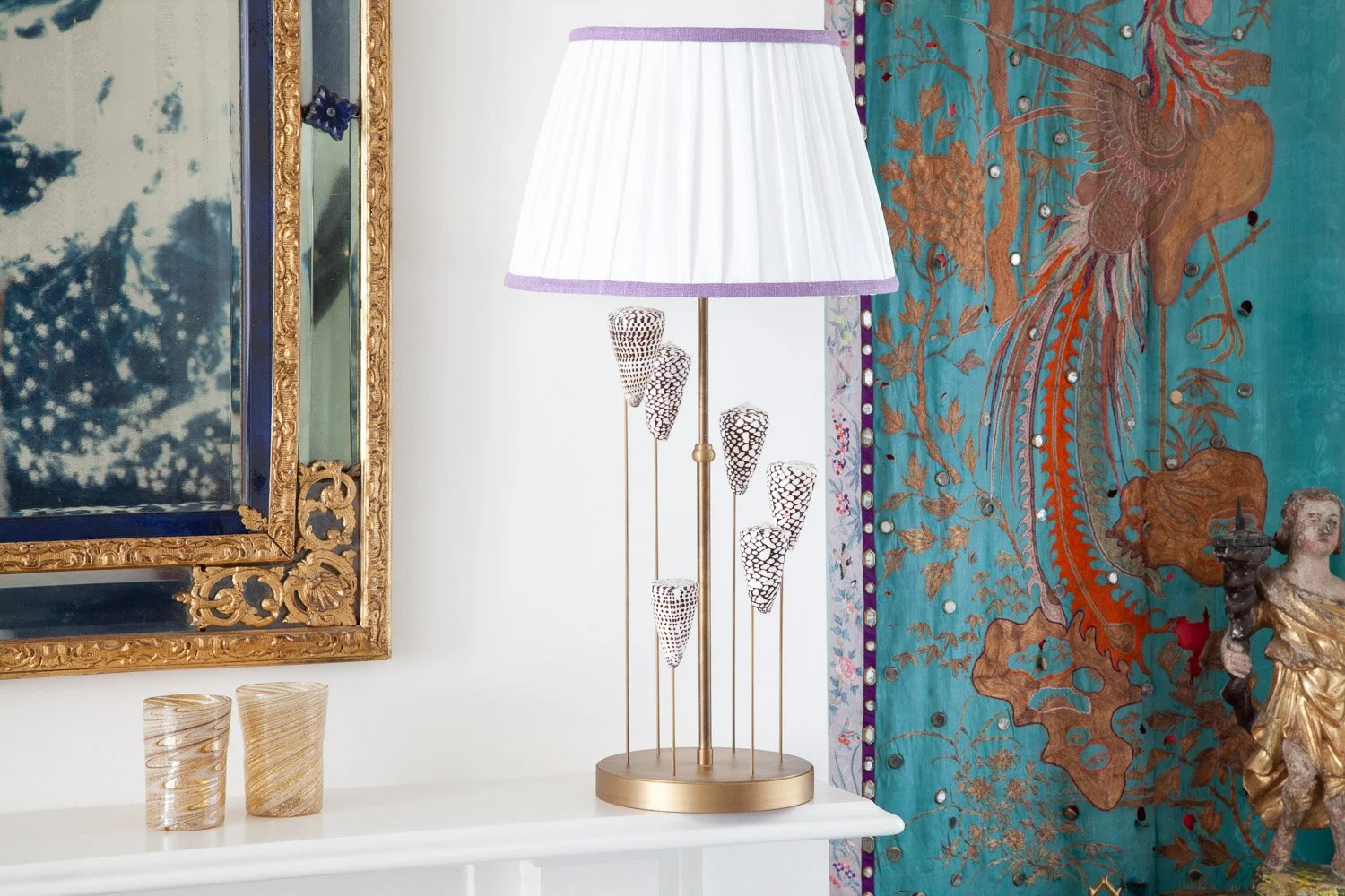Isabelle Bizard seashell drop lamp and Murano glass tumblers on a mantel, interior photographer