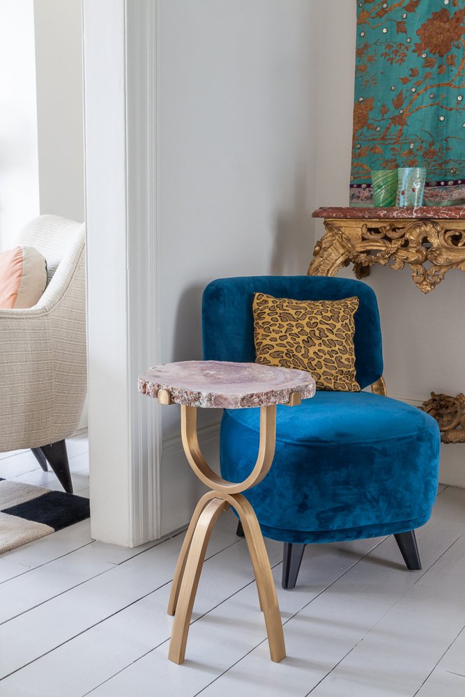 Isabelle Bizard Leblon side table with pink quartz, beside a blue velvet armchair, interior design photographer London