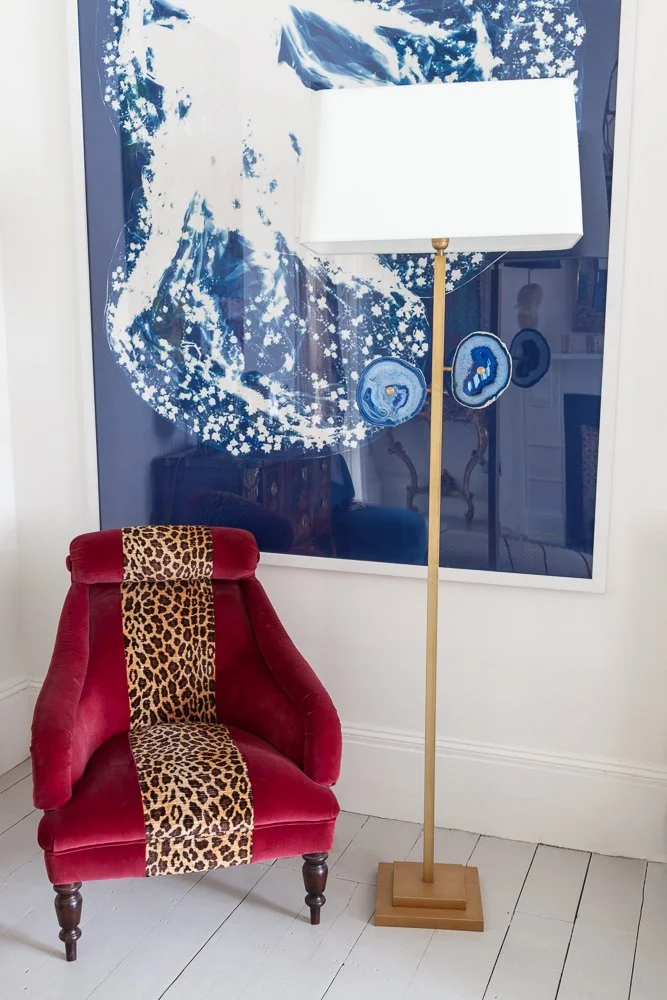 Isabelle Bizard Rio floor lamp with blue agates, beside a red velvet leopard-trim armchair, interior photographer London