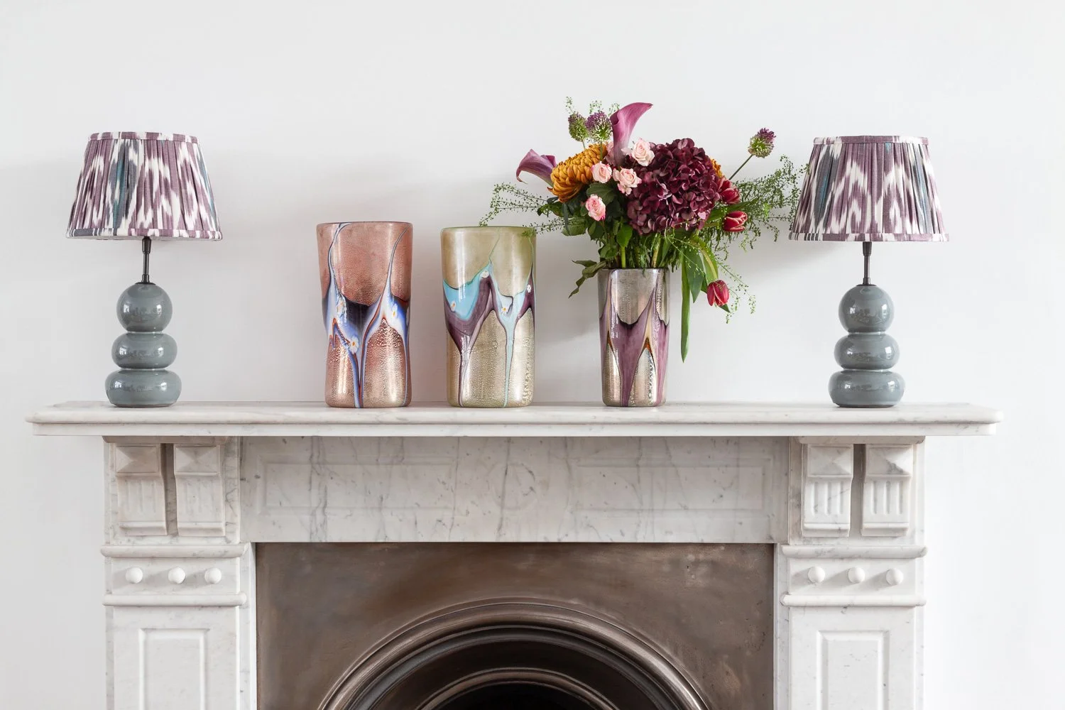 Isabelle Bizard Gordes ceramic table lamps and Murano glass vases, styled on a mantel with fresh flowers, interior design photographer