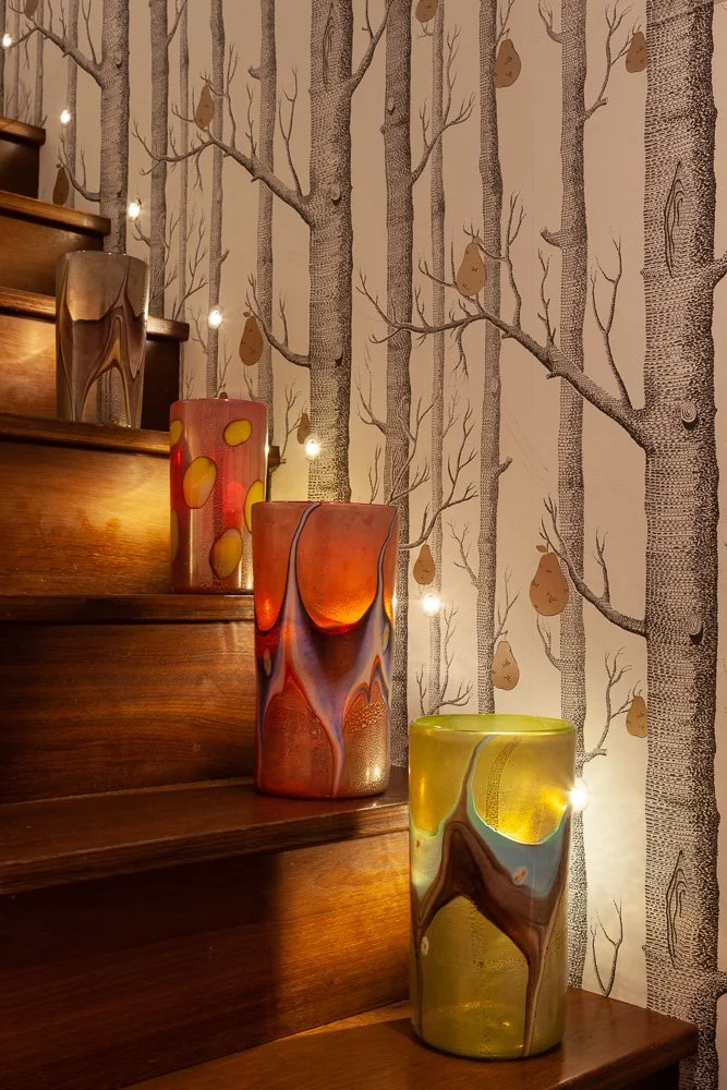 Isabelle Bizard Murano glass vases in assorted colours, styled on a wooden staircase, interior design photography