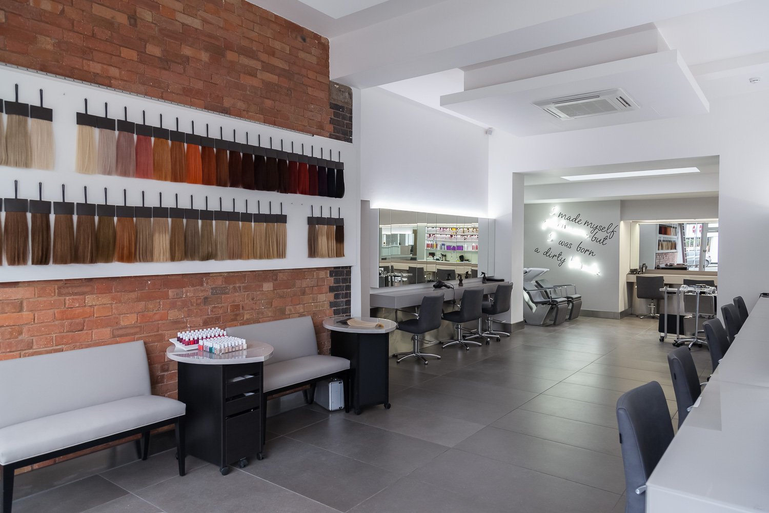 Hair salon interior with colour swatch display and exposed brick wall, interior design photographer