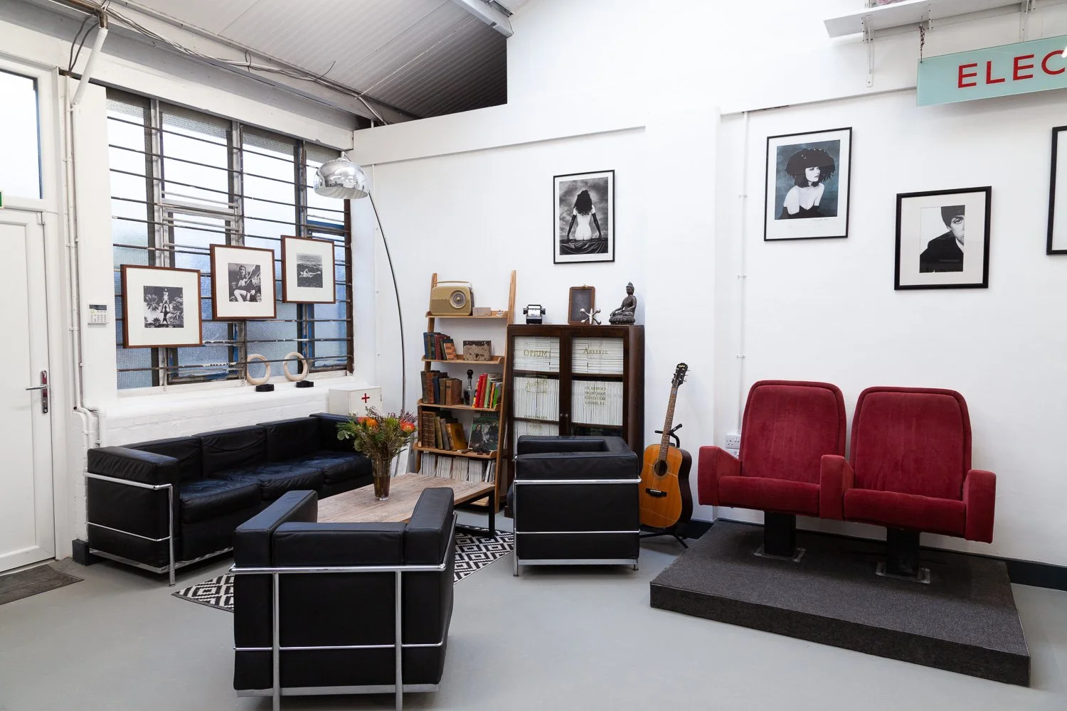 Photographic studio lounge area with vintage red seating and framed prints, interior design photographer, Essex