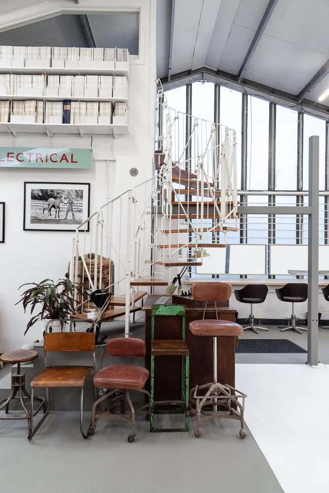 Photographic studio with mezzanine spiral staircase and vintage props, interior photography, Essex