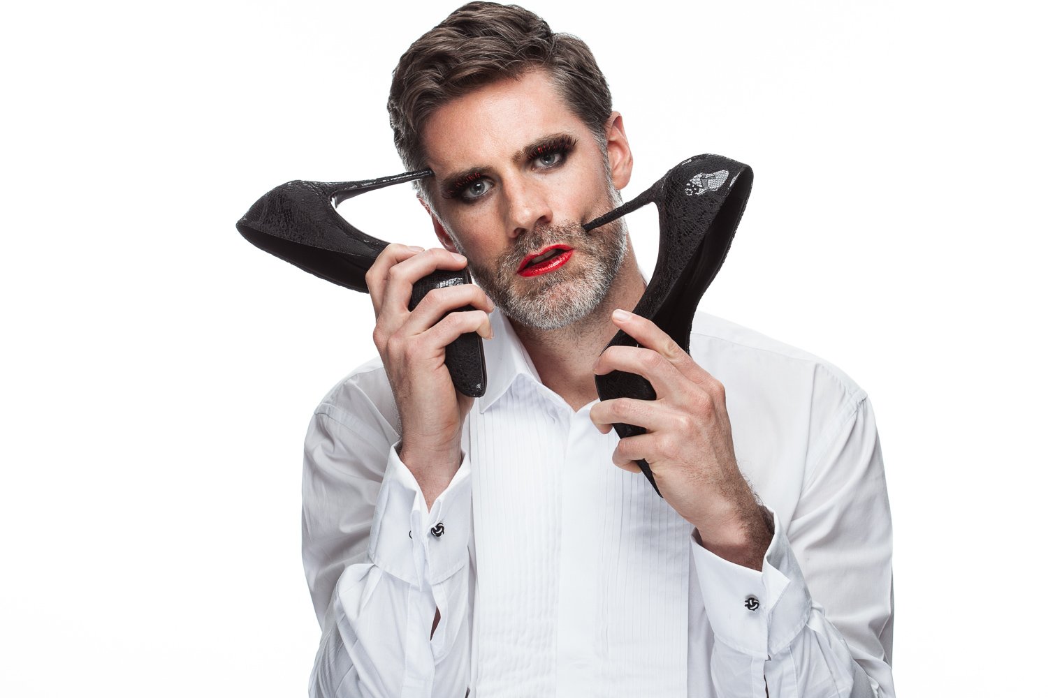 Close-up of a male model with a high-heeled shoe, white shirt, styled and art directed by Laurence Trolet, editorial photography