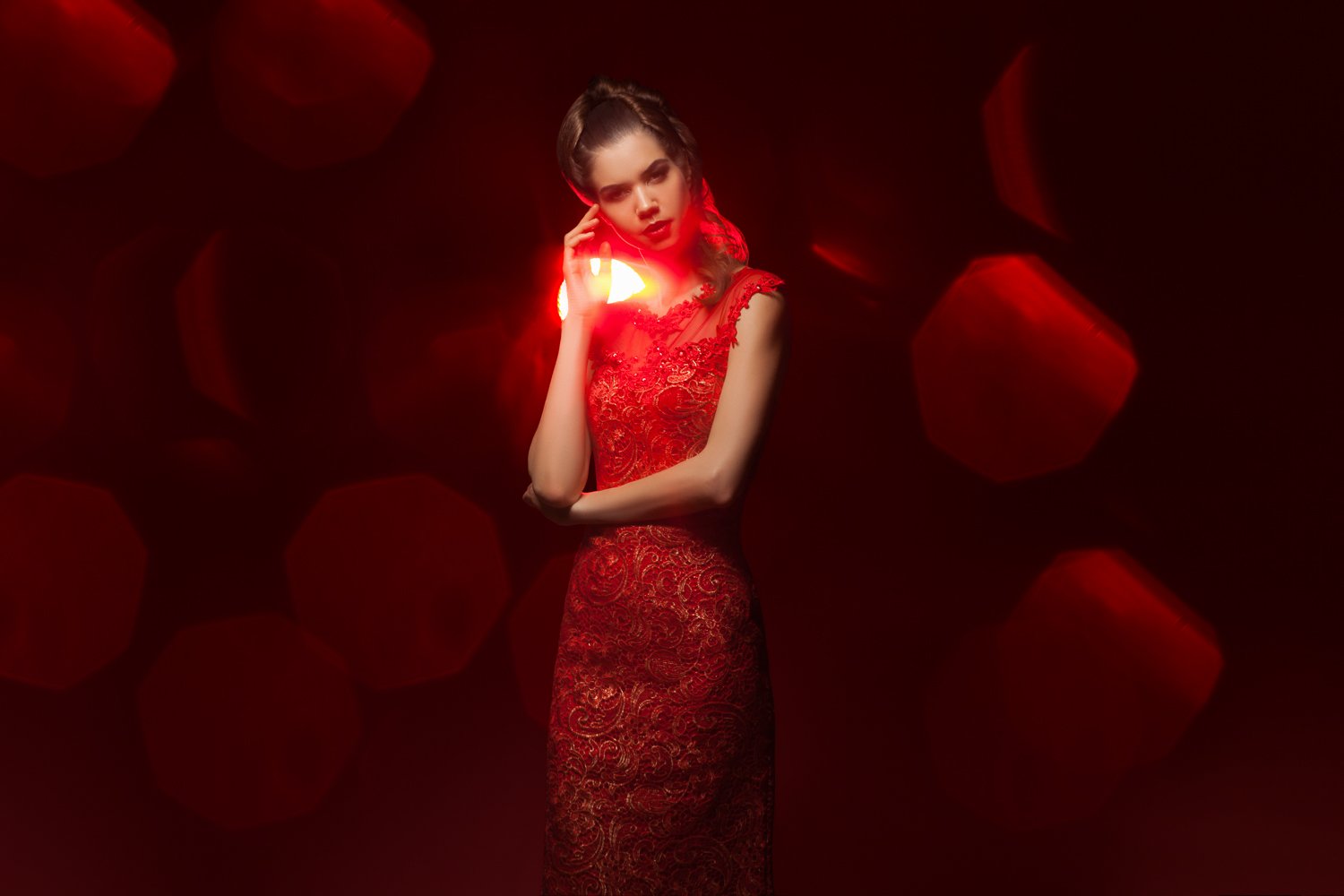 Model in a red gown with rose bokeh foreground, styled and art directed by Laurence Trolet, editorial photography