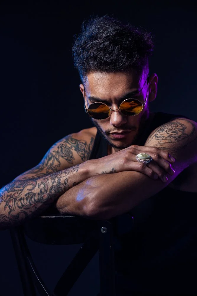Male model with tattoos and sunglasses, moody lighting, styled and art directed by Laurence Trolet, fashion and editorial photography