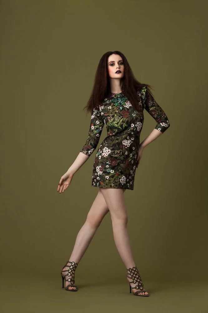 Model in an olive floral embroidered dress, walking pose, styled and art directed by Laurence Trolet, editorial fashion photography