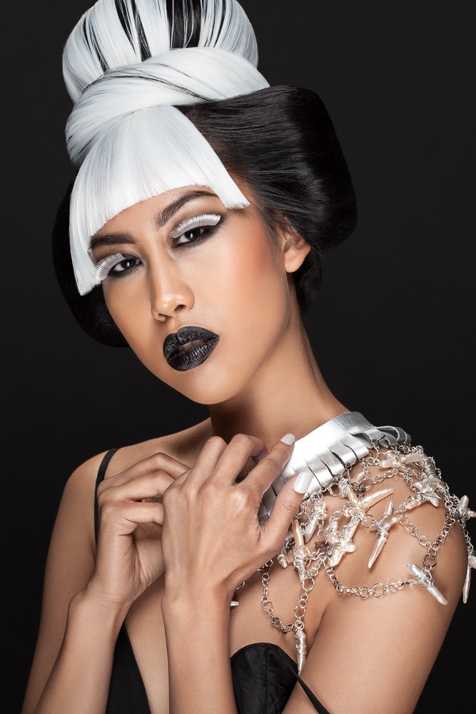 Model with a sculpted white fringe, silver statement necklace draped over her shoulder, styled and art directed by Laurence Trolet, branding photographer