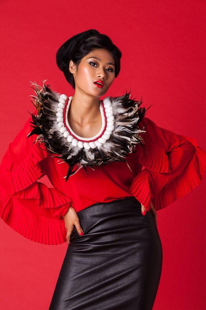 Close-up of a model in a red ruffled top with a feather collar, styled and art directed by Laurence Trolet, editorial photography