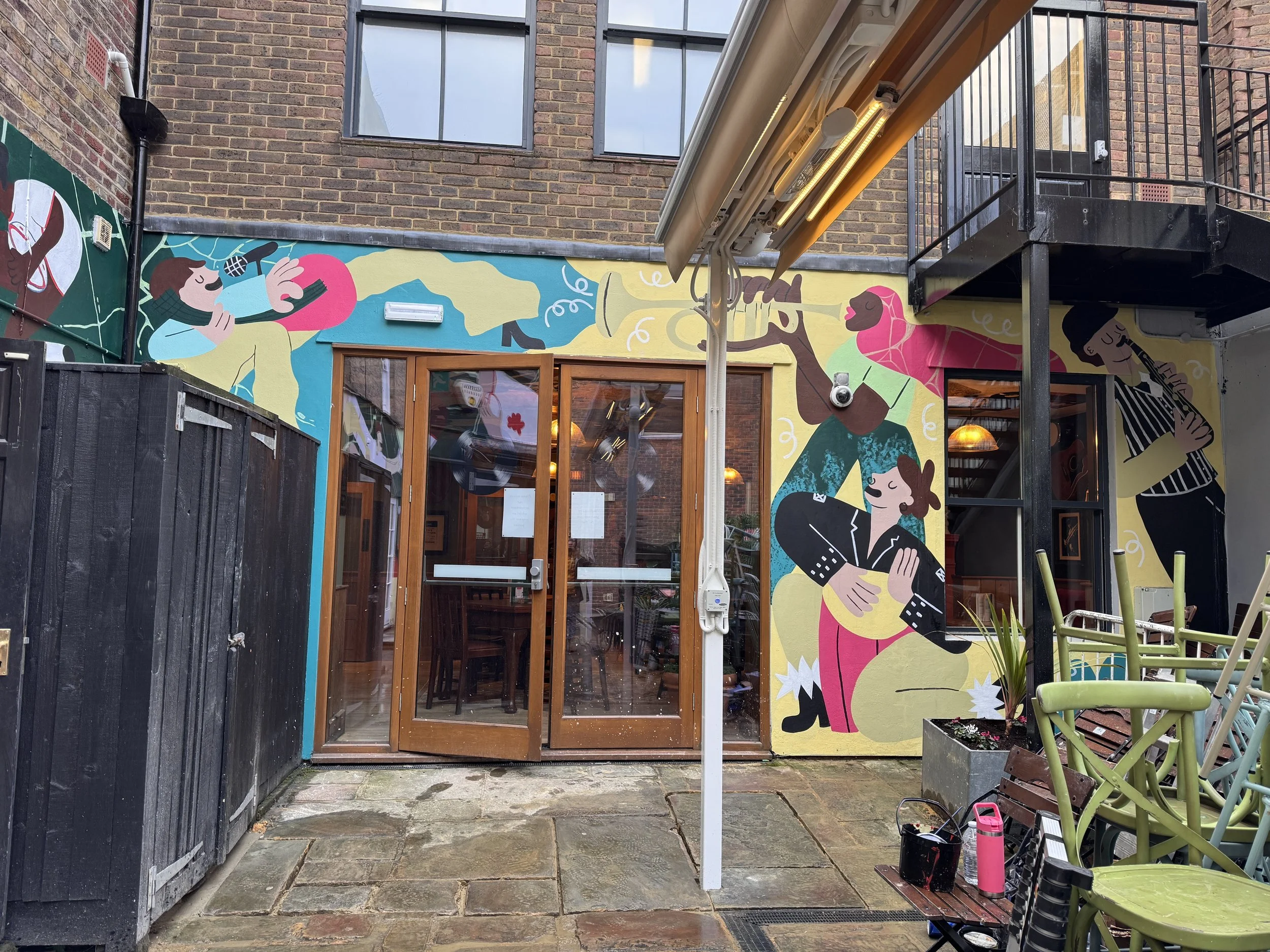 Mural design created for awkward space. The mural shows 4 figures who are playing musical instruments.